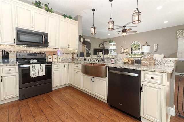 kitchen with tasteful backsplash, ceiling fan, pendant lighting, kitchen peninsula, and appliances with stainless steel finishes