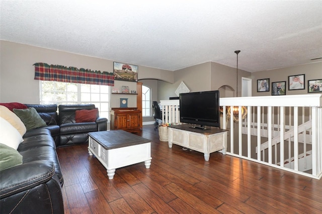 living room featuring dark hardwood / wood-style flooring and a textured ceiling