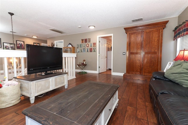 living room featuring a textured ceiling and dark hardwood / wood-style flooring