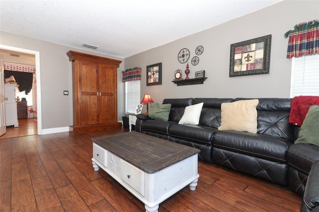 living room with dark wood-type flooring and a textured ceiling