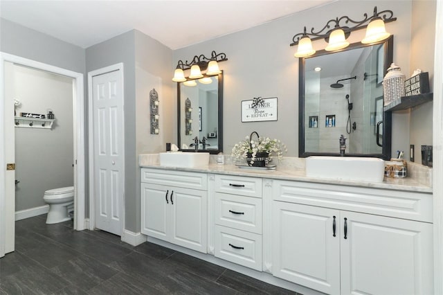 bathroom featuring a shower with shower door, toilet, and vanity