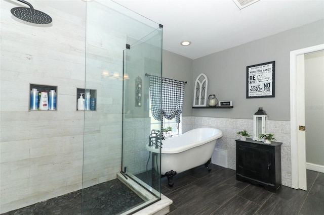 bathroom featuring tile walls and plus walk in shower