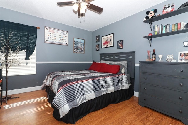 bedroom with ceiling fan and wood-type flooring