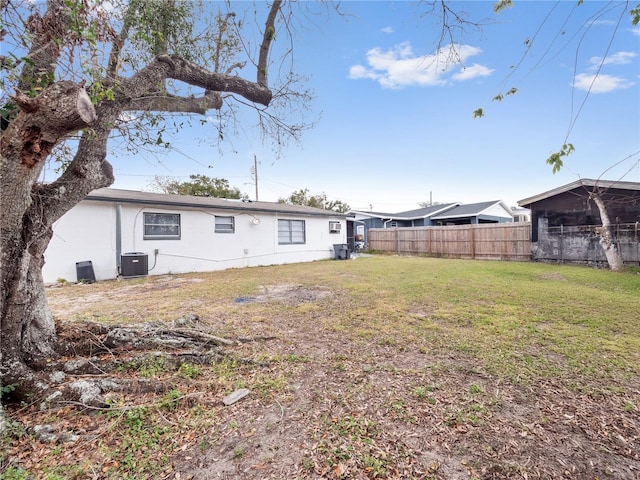 back of house featuring a lawn and central air condition unit