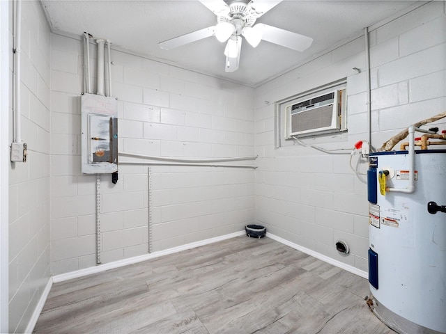 laundry room with an AC wall unit, ceiling fan, water heater, and light wood-type flooring