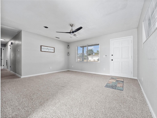 spare room with ceiling fan and carpet