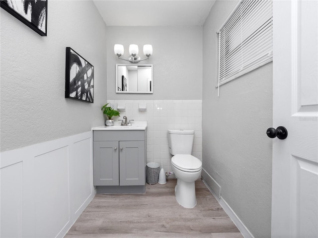 bathroom with toilet, vanity, and hardwood / wood-style floors