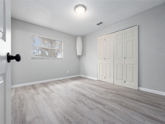 unfurnished bedroom featuring a closet and light hardwood / wood-style flooring