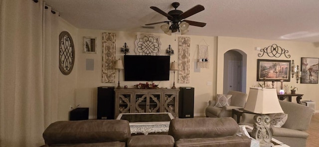 living room with ceiling fan and a textured ceiling