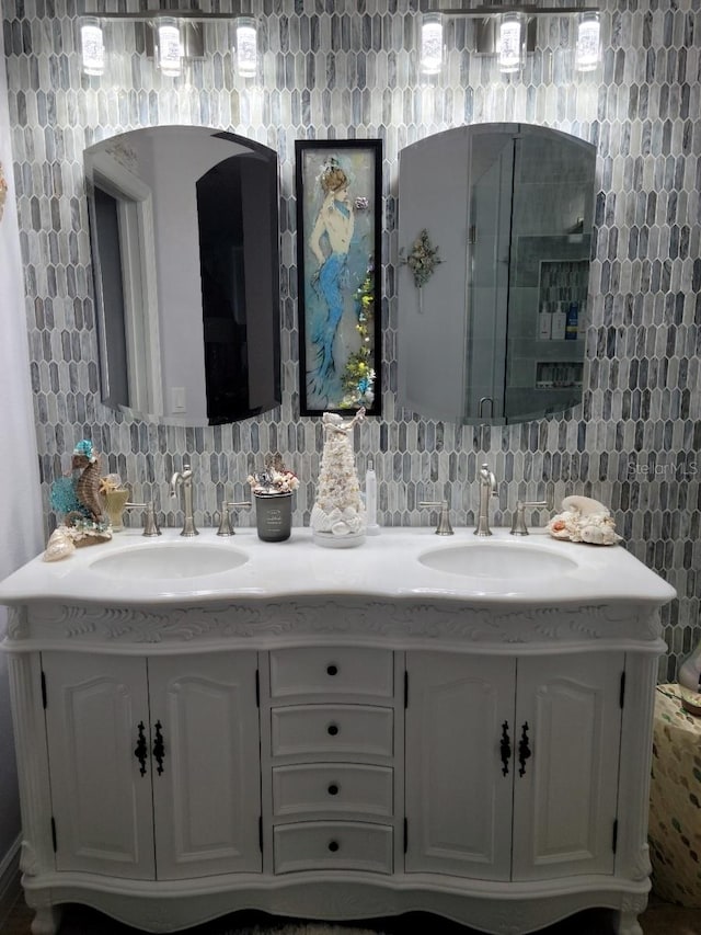 bathroom featuring vanity, a shower with door, and decorative backsplash