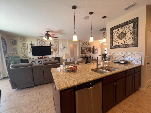 kitchen with sink, dark brown cabinets, a center island with sink, decorative light fixtures, and stainless steel dishwasher