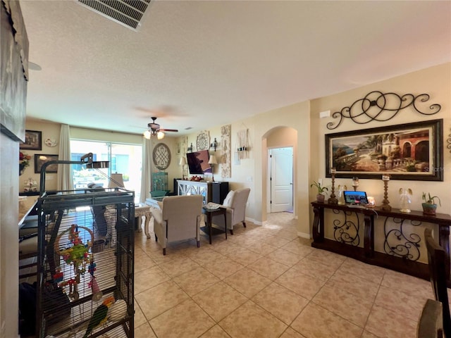 tiled living room with ceiling fan