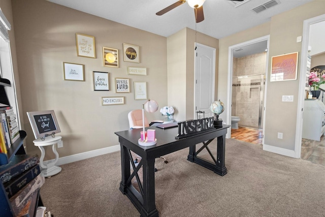 carpeted home office with ceiling fan