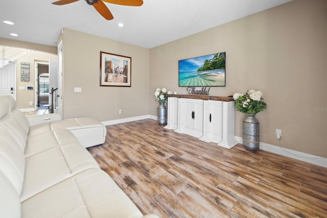 living room with light hardwood / wood-style flooring and ceiling fan