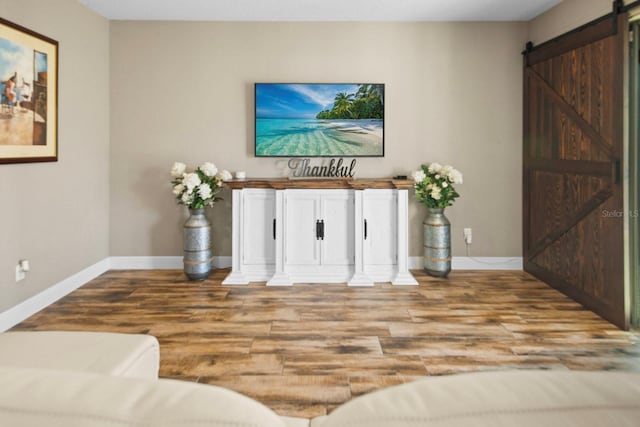 living room with a barn door and light hardwood / wood-style flooring