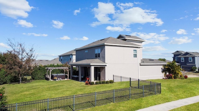 rear view of house featuring a yard and a jacuzzi