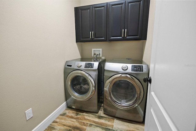 washroom with cabinets and washer and dryer