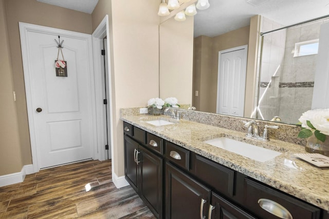 bathroom with vanity, wood-type flooring, and a tile shower