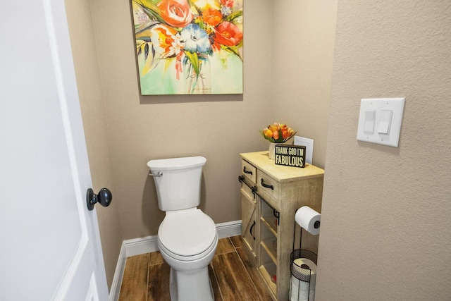 bathroom featuring wood-type flooring and toilet