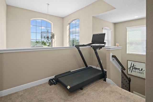 workout area with carpet flooring and a chandelier