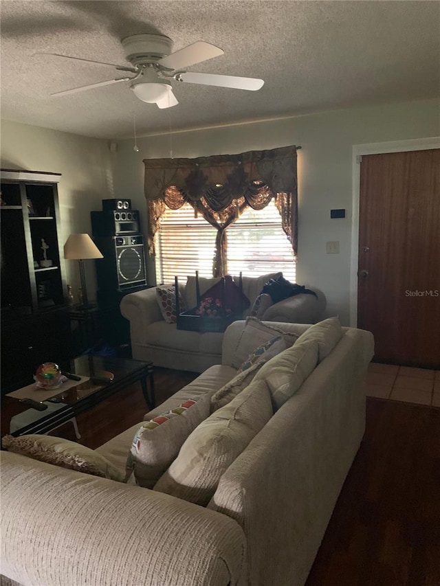 living room with a textured ceiling and ceiling fan