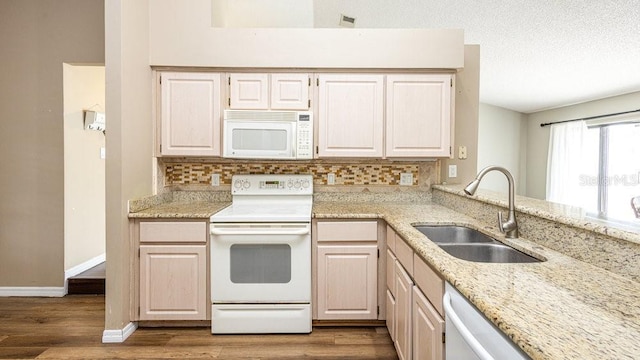 kitchen featuring light wood-type flooring, backsplash, sink, and white appliances