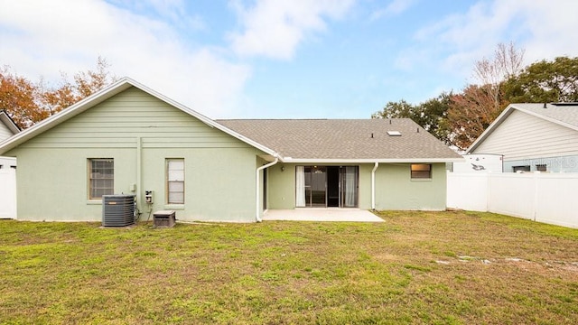 rear view of property with a lawn, central air condition unit, and a patio