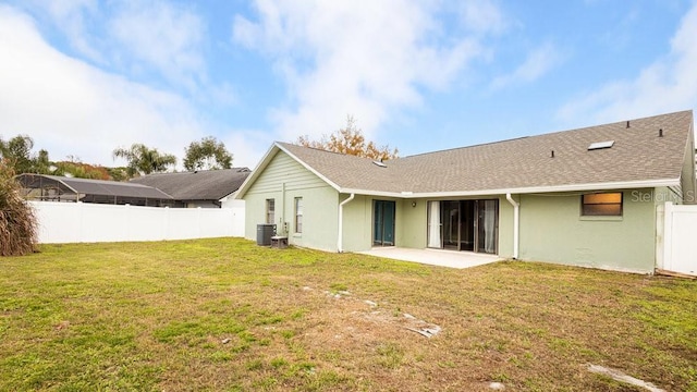 rear view of property with central AC, a lawn, and a patio