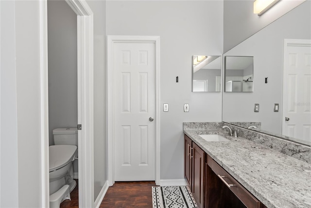 bathroom with hardwood / wood-style flooring, toilet, and vanity