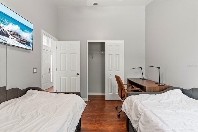 bedroom with dark wood-type flooring and a closet