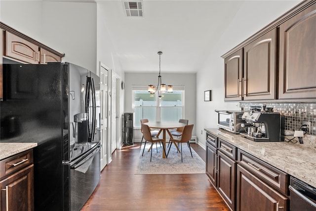 kitchen featuring hanging light fixtures, dark brown cabinetry, black fridge, and an inviting chandelier