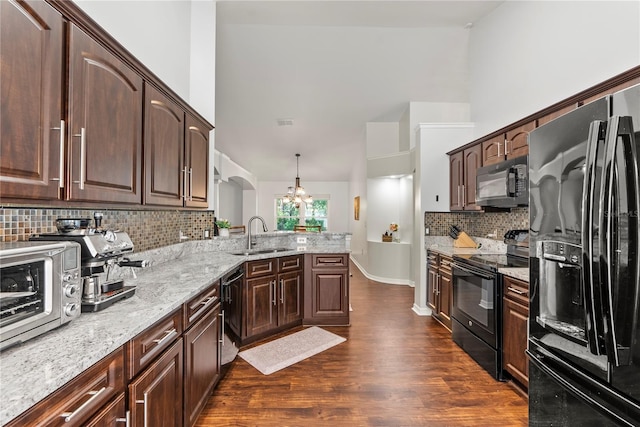 kitchen featuring backsplash, black appliances, sink, hanging light fixtures, and a chandelier