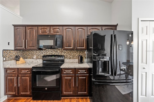 kitchen featuring decorative backsplash, black appliances, dark brown cabinets, and light hardwood / wood-style flooring