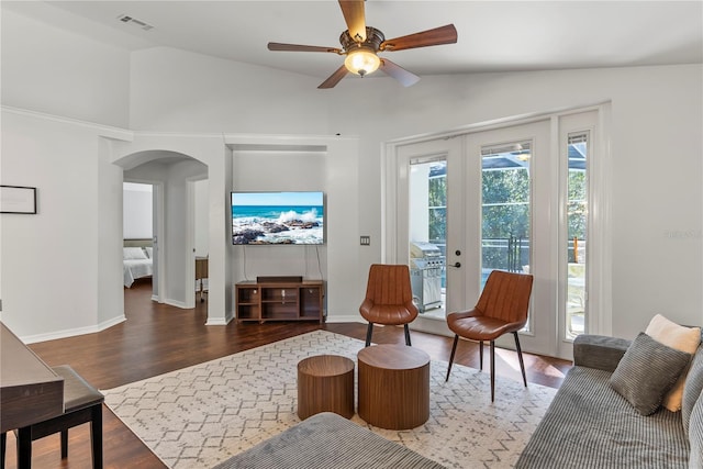 living room with ceiling fan, dark wood-type flooring, and vaulted ceiling