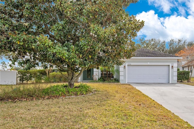 view of property hidden behind natural elements featuring a front yard and a garage