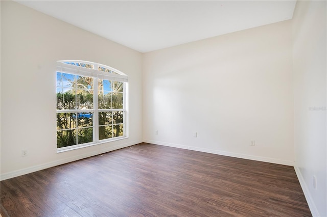 empty room with dark hardwood / wood-style flooring