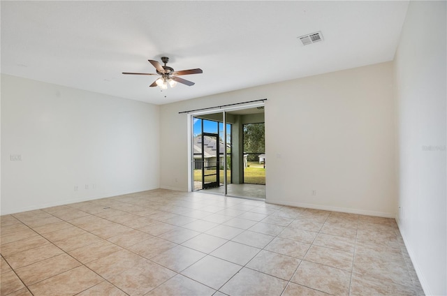 tiled spare room with ceiling fan