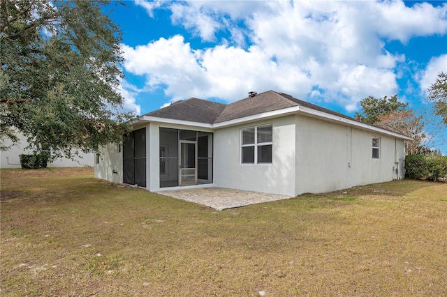 back of property featuring a patio area, a sunroom, and a lawn