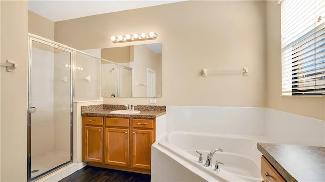 bathroom with vanity, hardwood / wood-style flooring, and independent shower and bath