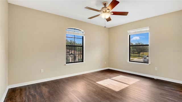 empty room with ceiling fan and dark hardwood / wood-style flooring