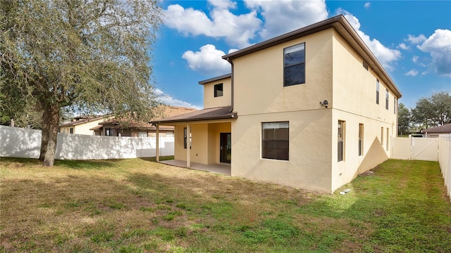 rear view of house with a patio and a yard