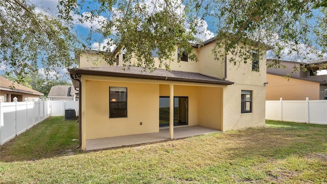 back of property with cooling unit, a patio area, and a yard