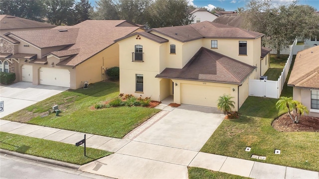 mediterranean / spanish home with a garage and a front lawn