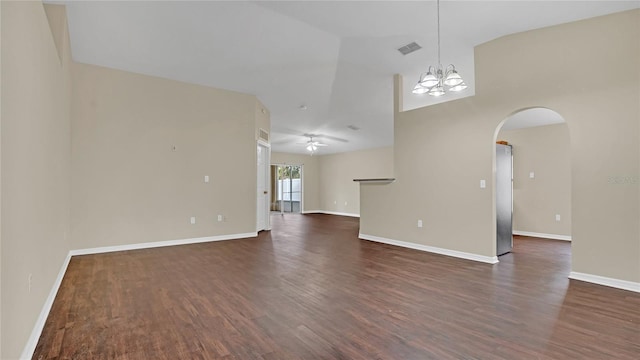 spare room with ceiling fan with notable chandelier and dark wood-type flooring