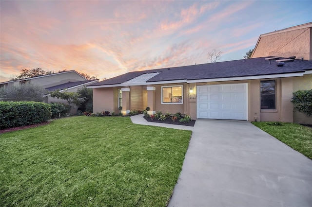 ranch-style home with a garage, a yard, and solar panels