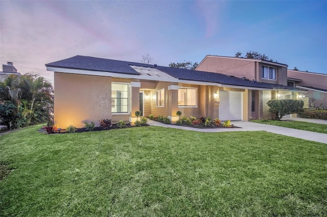 view of front facade with a garage and a lawn