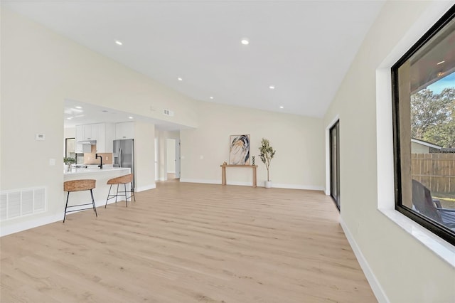 living room featuring lofted ceiling and light wood-type flooring