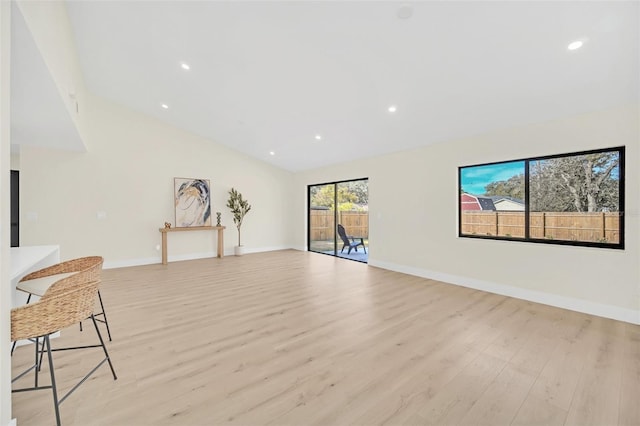 unfurnished living room featuring lofted ceiling and light wood-type flooring