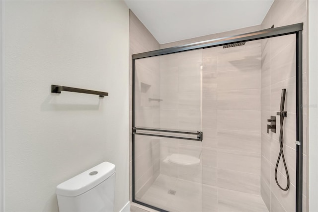 bathroom with toilet and a shower with shower door