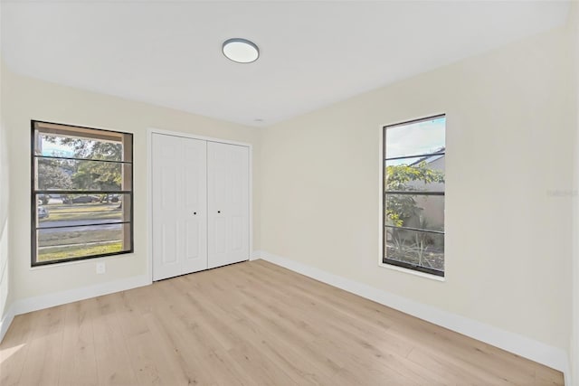 unfurnished bedroom featuring a closet and light wood-type flooring